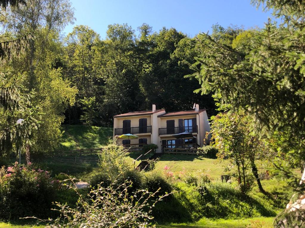 une maison au milieu d'un champ arboré dans l'établissement Au Songe du Valier- Chalets, à Seix