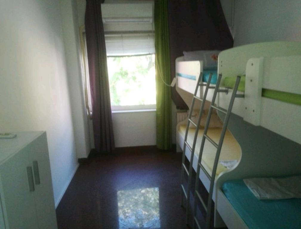 a small room with three bunk beds and a window at Stars Aspava Blue HOSTEL in Podgorica