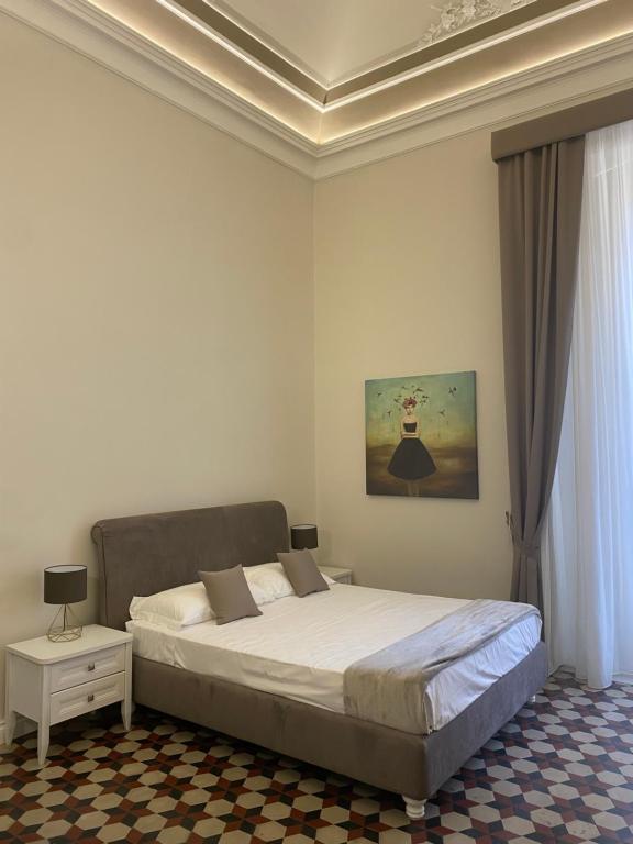 卡塔尼亞的住宿－DOMUS IOLE appartamento nel centro storico，一间卧室设有一张带格子天花板的床。