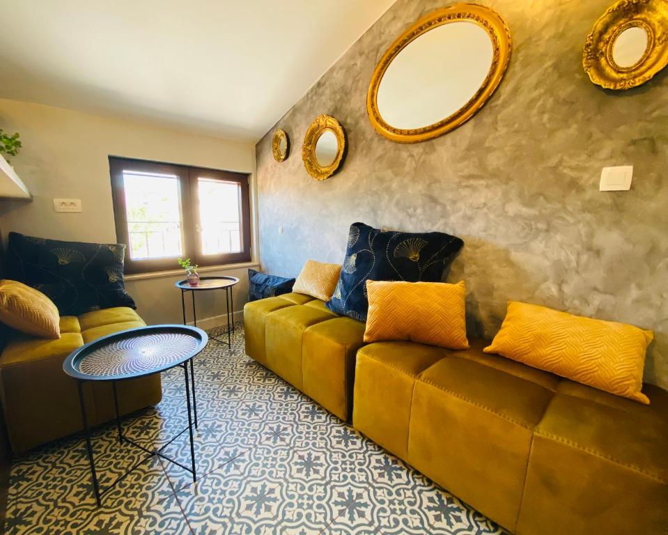 a living room with a couch and two mirrors at BOUTIQUE ROOMS Mare Fabulas in Rovinj