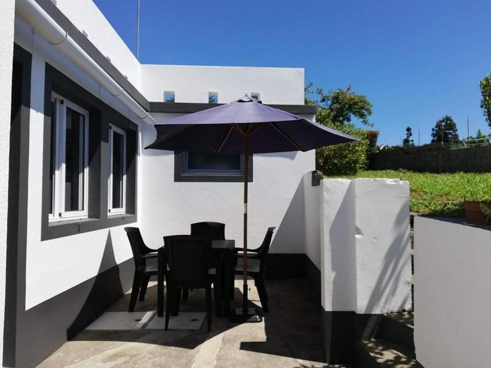 a patio with a table and an umbrella at Casa Três Campos in Povoação