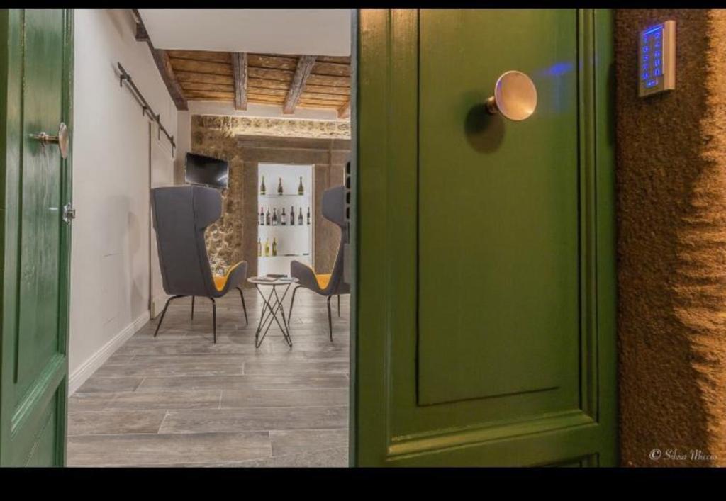 een groene deur die leidt naar een kamer met stoelen bij SDL luxury home Al Pavone in Viterbo