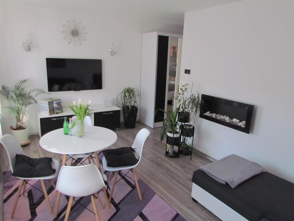 a living room with a table and chairs and a couch at Apartament Ella in Polanica-Zdrój