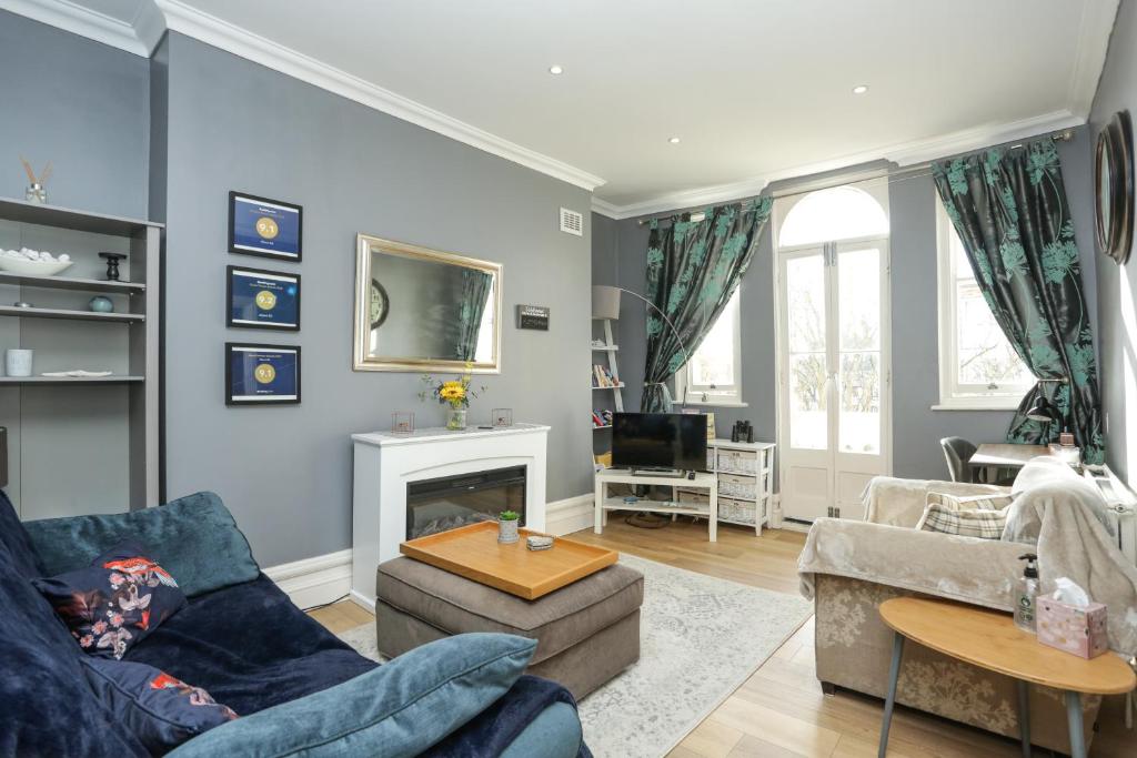 a living room with blue walls and a fireplace at Sea View - Balcony - Free Parking in Ramsgate