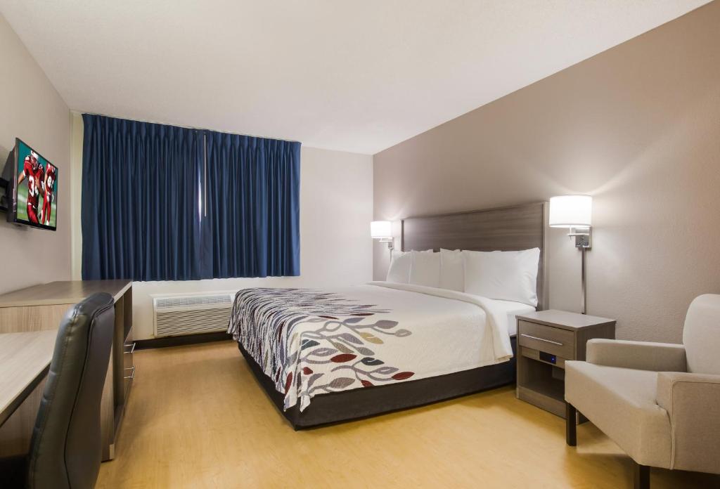 une chambre d'hôtel avec un lit et une chaise dans l'établissement Red Roof Inn Lawrenceburg, à Lawrenceburg