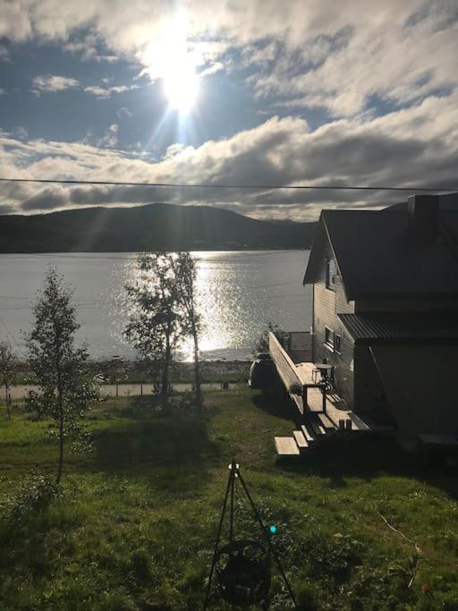 a house with a view of a lake and the sun at Trivelig fritidshus på Årnes, Senja in Straumstad