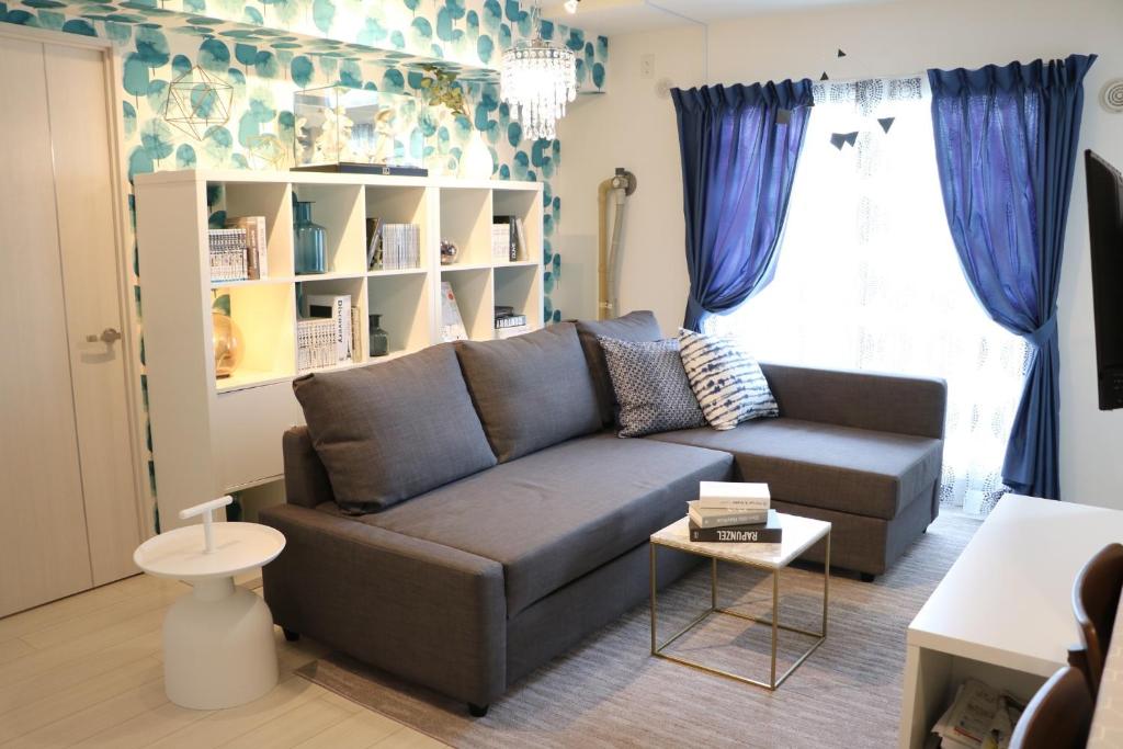 a living room with a couch and blue curtains at Hassamu 3 Jo 1-11-1 Corole Kotoni - Vacation STAY 11468 in Sapporo