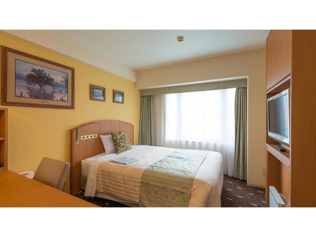 a hotel room with a bed and a television at Boston Plaza Kusatsu Biwa Lake - Vacation STAY 15462v in Kusatsu