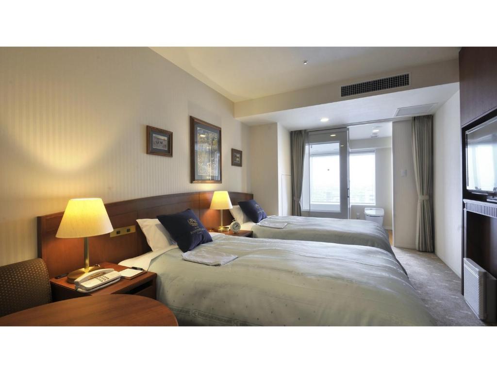 a hotel room with two beds and a window at Boston Plaza Kusatsu Biwa Lake - Vacation STAY 15448v in Kusatsu