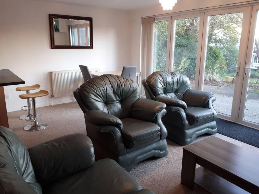 a living room with two leather chairs and a table at RentUnique Spinney SpaciousSuper Snug 1 bed home. in Ifield
