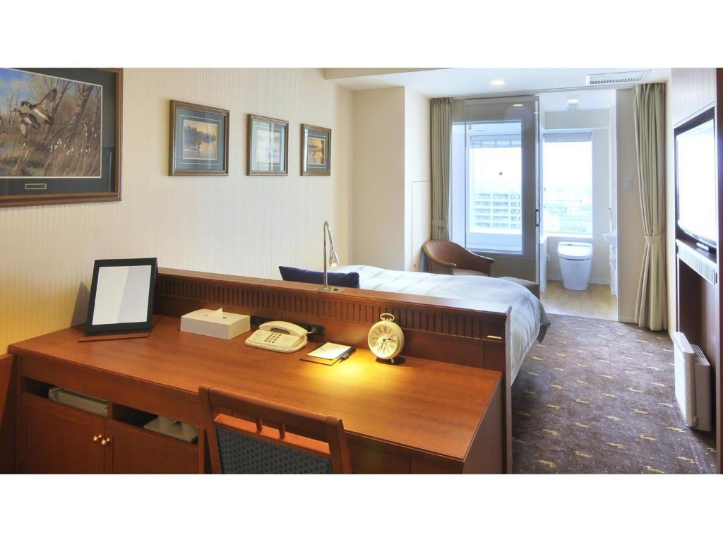 a hotel room with a desk and a bed at Boston Plaza Kusatsu Biwa Lake - Vacation STAY 15445v in Kusatsu