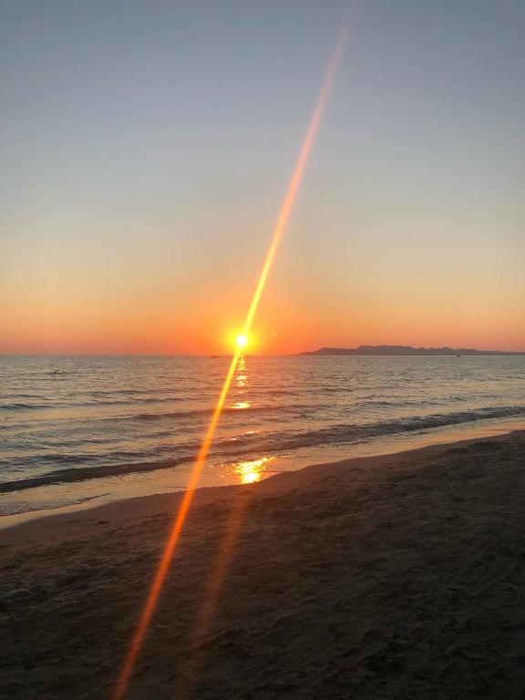 a sunset on the beach with the sun setting at Dea Luxury Apartament Beach in Durrës