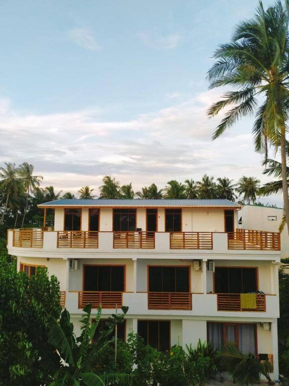 un edificio con una palmera en el fondo en Cowry Inn, en Fulidhoo
