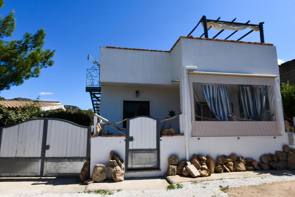 uma casa branca com um portão e uma janela em Bentosa em Enas