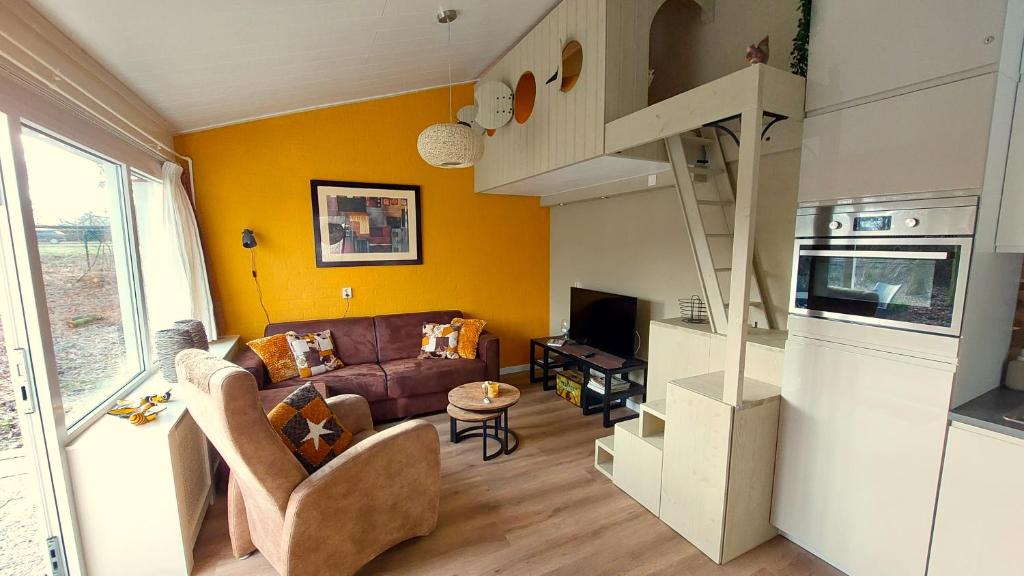 a living room with a couch and a staircase at Vakantiehuis Amber in Simpelveld