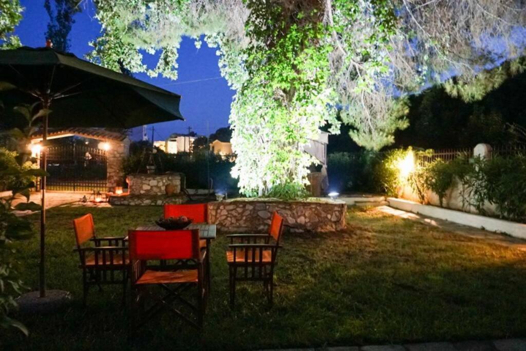 - une table et des chaises dans la cour la nuit dans l'établissement VILLA DREAM, à Skiathos Chora