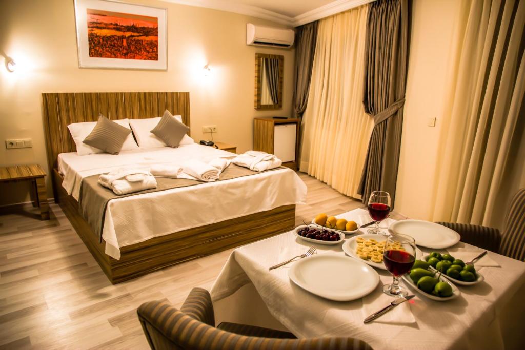 イスタンブールにあるBerlin Hotel Nisantasiのベッドとテーブル(食べ物付)が備わる客室です。