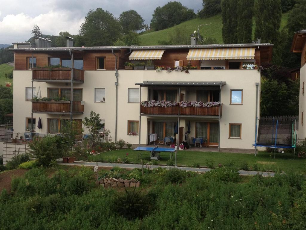 ein weißes Gebäude mit Balkon auf der Seite in der Unterkunft Apartments Almiva in Kastelruth