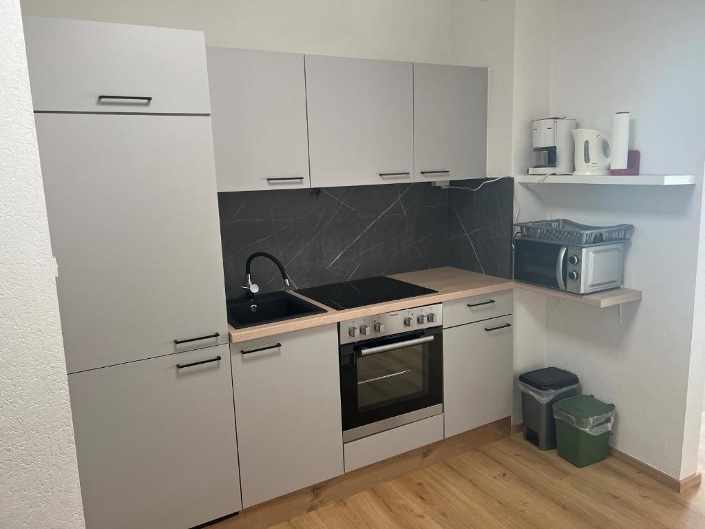 a kitchen with white cabinets and a sink and a stove at living Appartement in Flachau