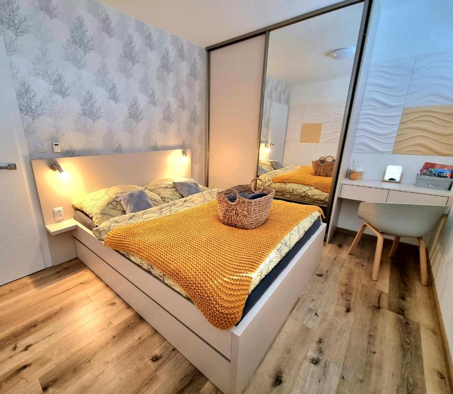 ein Schlafzimmer mit einem großen Bett und einem Spiegel in der Unterkunft Apartmán Nad Arénou NMNM in Nové Město na Moravě