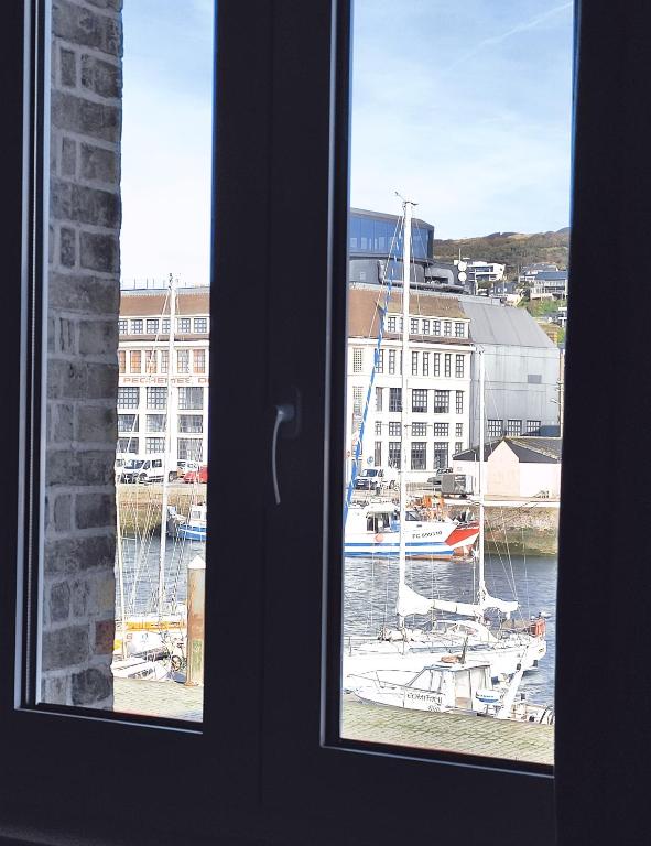a view from a window of a harbor with boats at L' ALBATROS vue sur le port in Fécamp