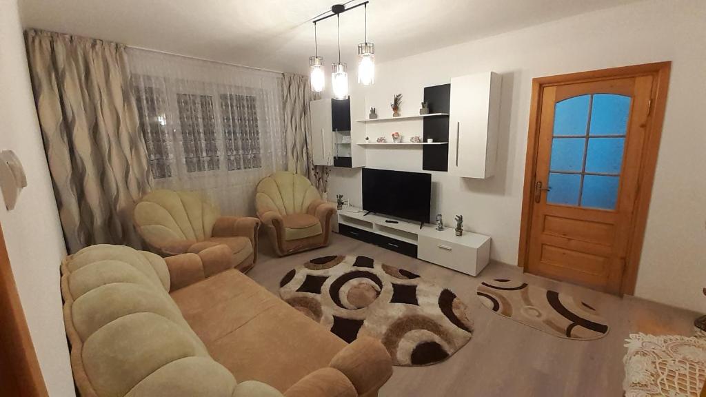 a living room with a couch and chairs and a television at Apartament ALEX-LUXURY in Târgu Ocna