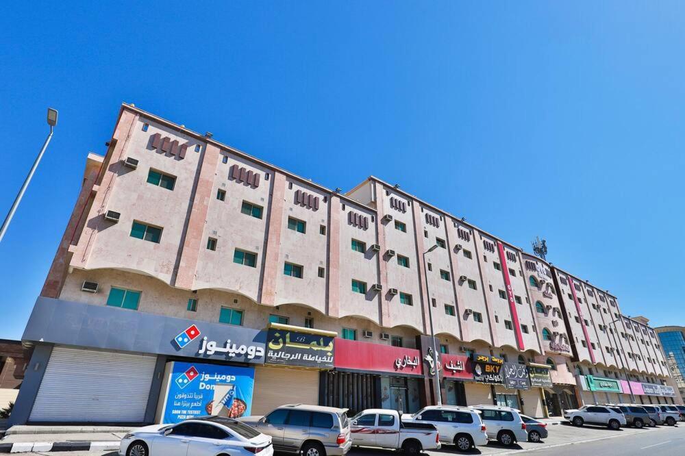 a large building with cars parked in front of it at نارين للشقق المفروشة in Taif
