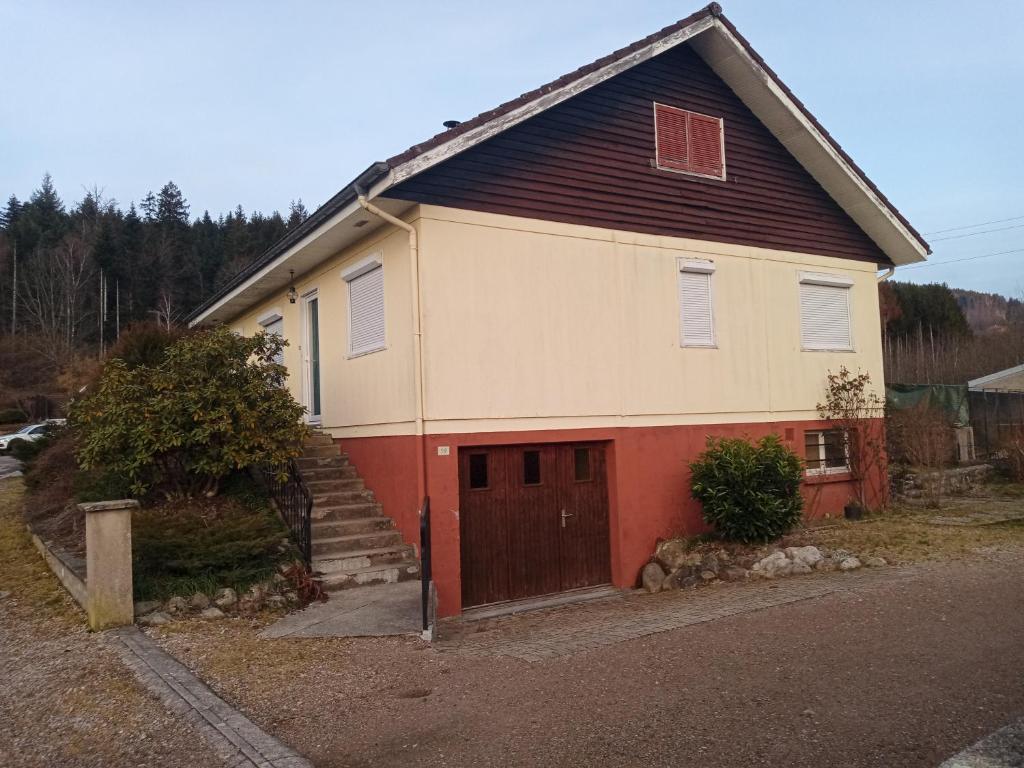 uma casa com uma porta castanha e uma garagem em Maison de vacances em Granges-sur-Vologne