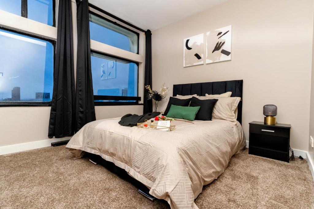 a bedroom with a large bed and large windows at JPG Tower Suite - 22nd Floor Canal & City Views in Manchester