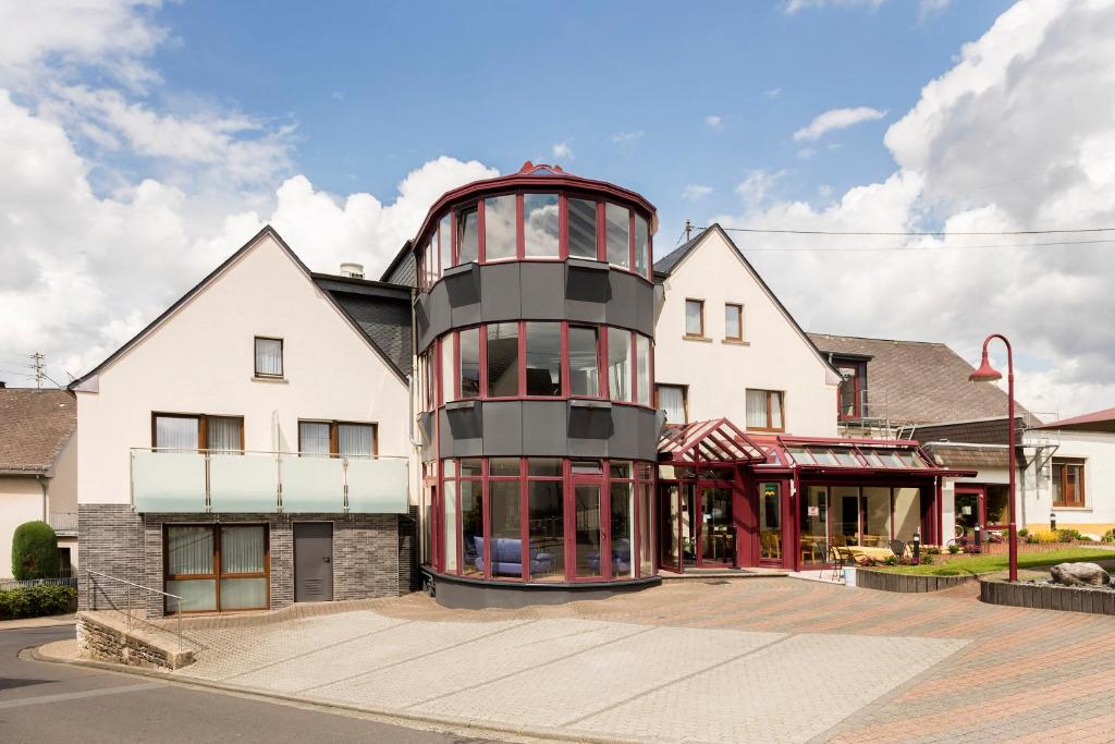 a house with a round tower in the middle of a street at Landhotel Wolf-Mertes in Sessenbach