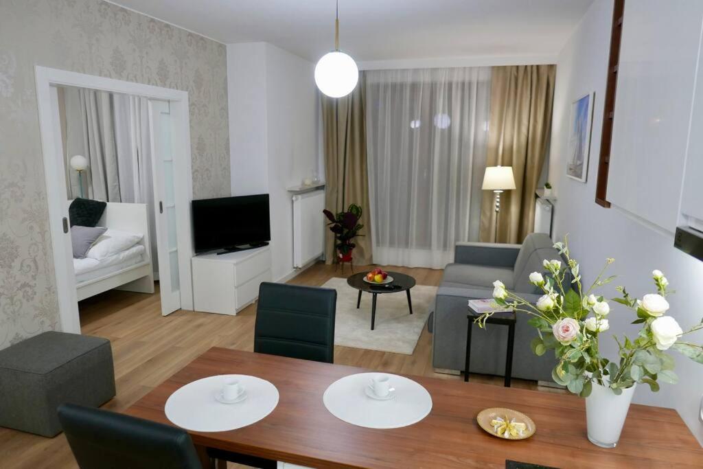 uma sala de estar com uma mesa de jantar e uma sala de estar em Kieślowskiego Apartment vis-a-vis Town Hall em Varsóvia