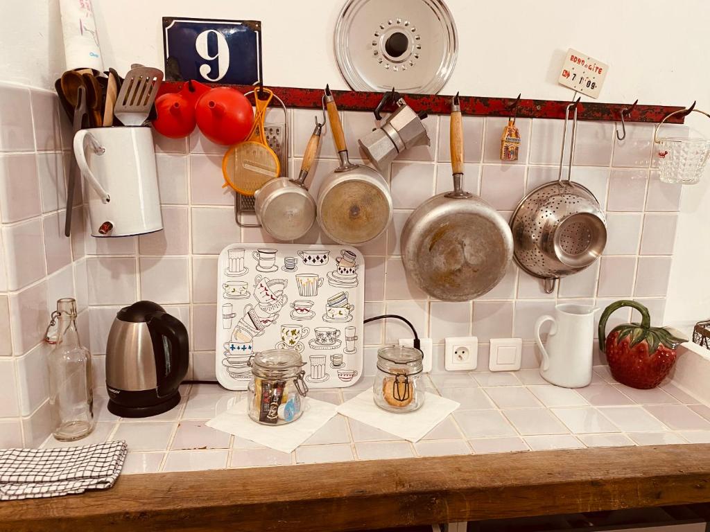 um balcão de cozinha com panelas, frigideiras e utensílios em Le petit carnot em Apt