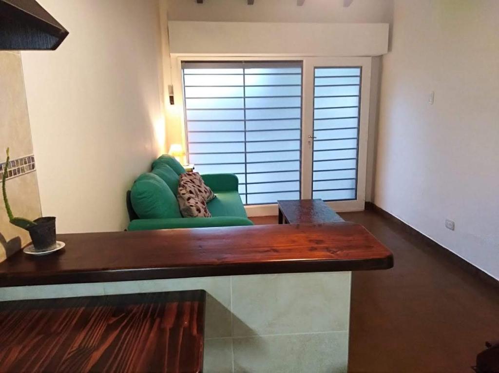a living room with a green couch and a window at Loft del Centro Mendoza in Mendoza