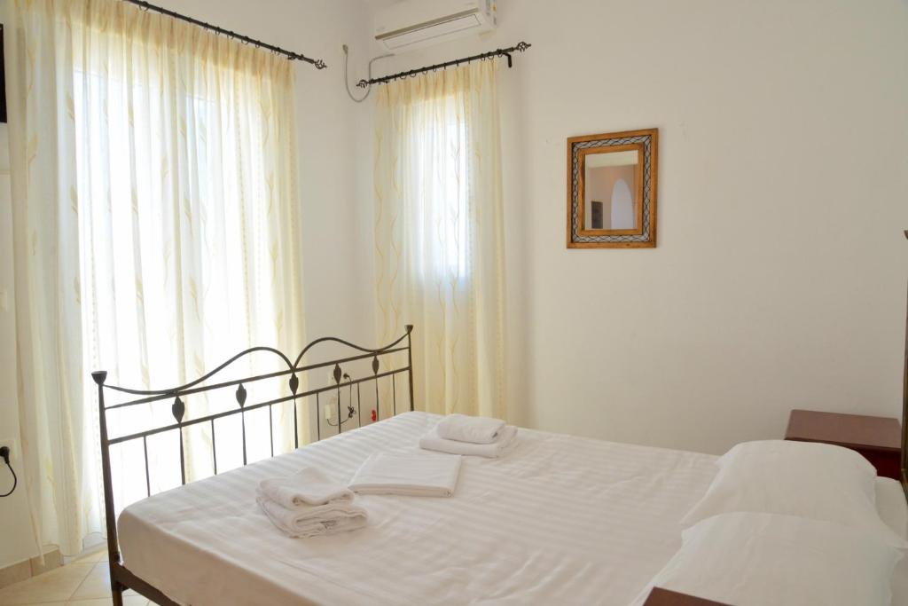 a bedroom with a bed with two towels on it at Trypiti Sea View Apartment in Tripiti