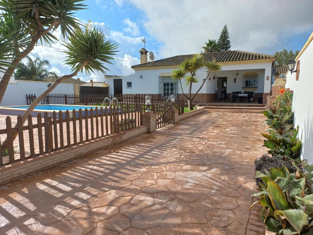 une maison avec une clôture et une piscine dans l'établissement Casa Rafael-Chalet con piscina privada, à Chiclana de la Frontera