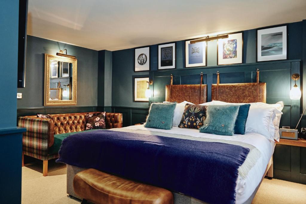 een slaapkamer met een groot bed en een bank bij Kings Arms in Egham