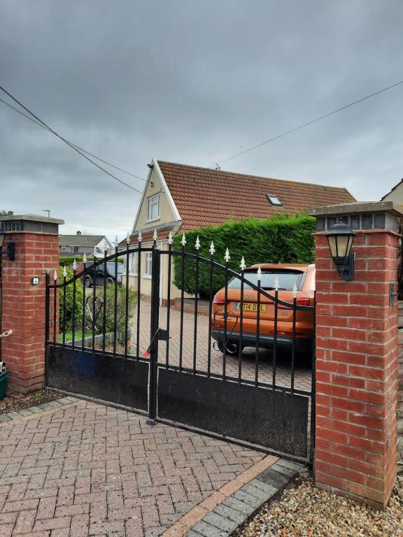 a black gate with a car parked in front of a house at Greenlands Guest House in Highbridge