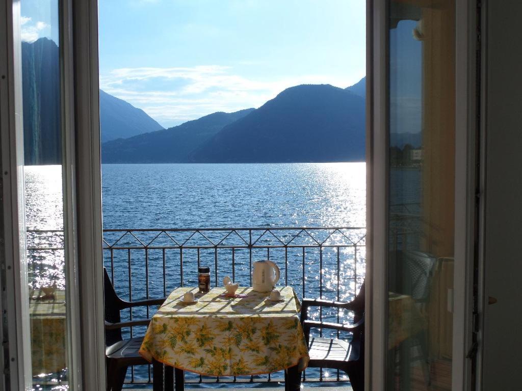einen Tisch auf einem Balkon mit Blick auf das Wasser in der Unterkunft Nido di Mariangela See-Ferienwohnung in Bellano