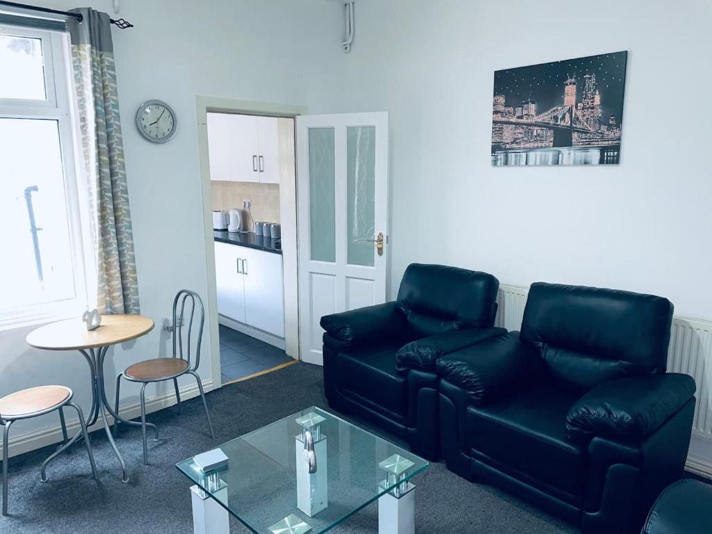 uma sala de estar com um sofá preto e uma mesa em Cheerful Town House in Coventry City Centre em Coventry