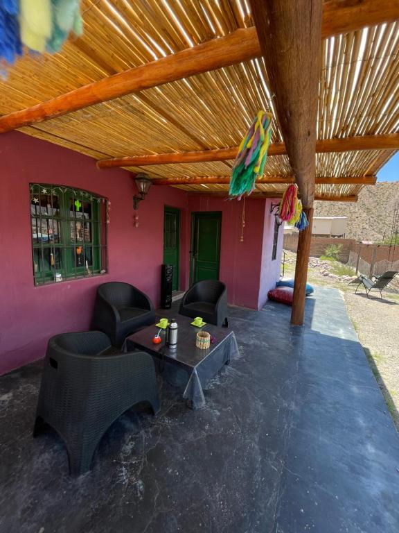 a living room with chairs and a table under a roof at El Rancho in Tilcara