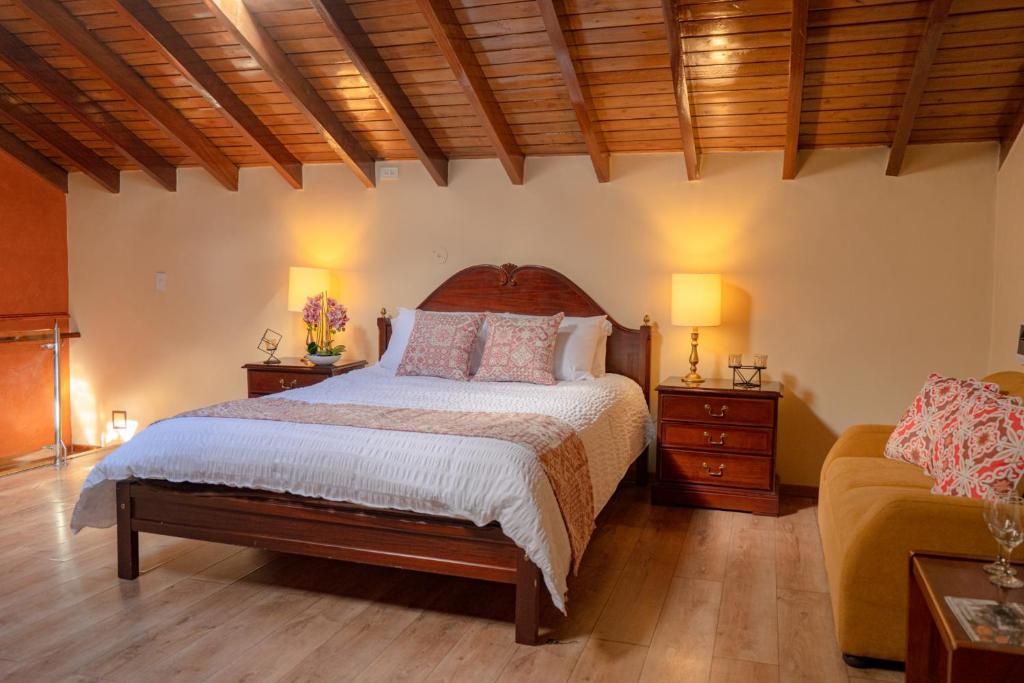 ein Schlafzimmer mit einem Bett, zwei Tischen und einem Sofa in der Unterkunft Fantástico Loft Centro Histórico Quito in Quito