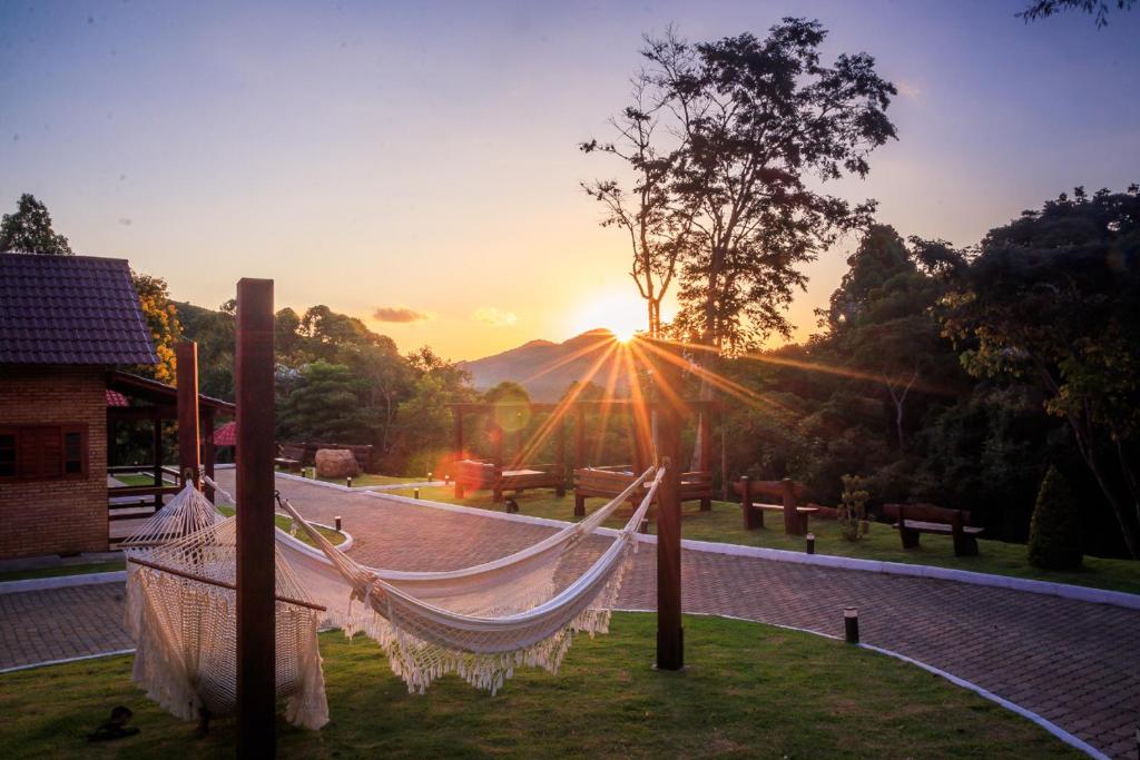 a hammock in a garden with the sunset in the background at Recanto da Ruína in Pedra Menina