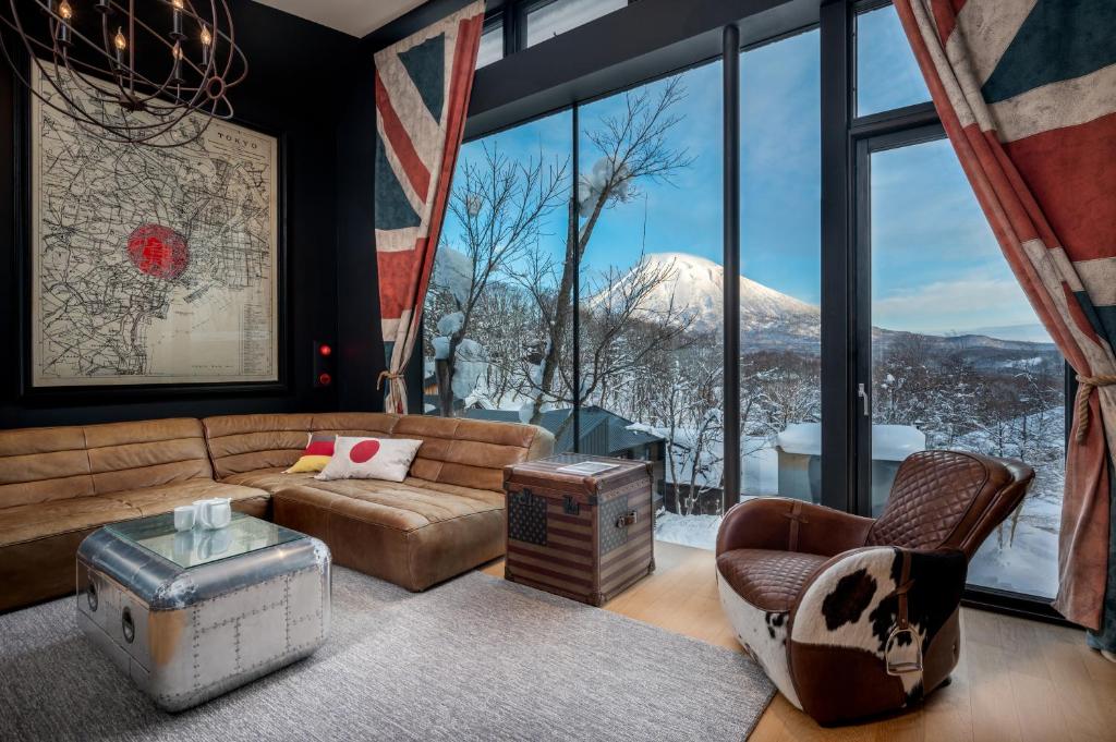 a living room with a couch and a large window at Millesime - operated by H2 Life in Niseko