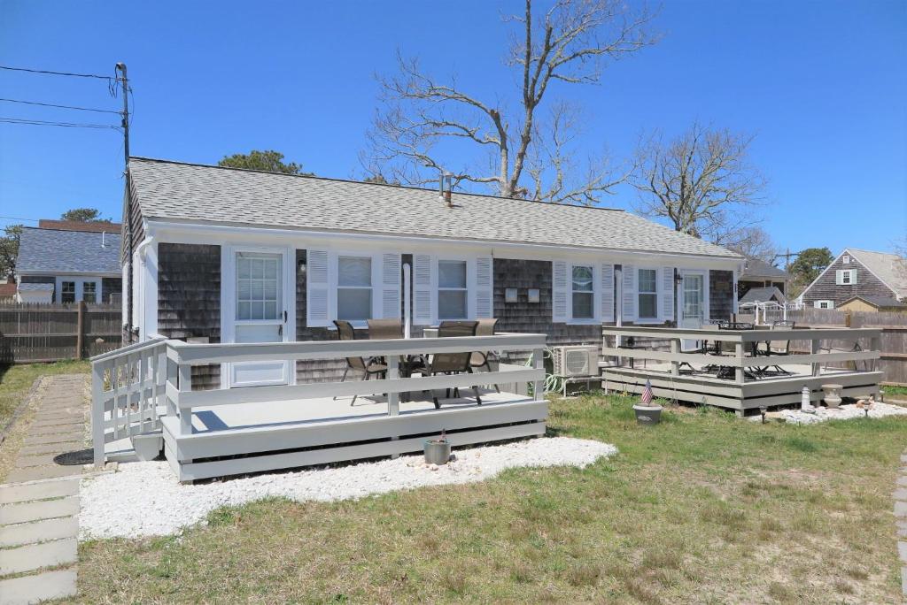 una casa con porche y bancos delante de ella en 2 Minute Walk to Beach, Cape Cod Escape, en Dennis Port