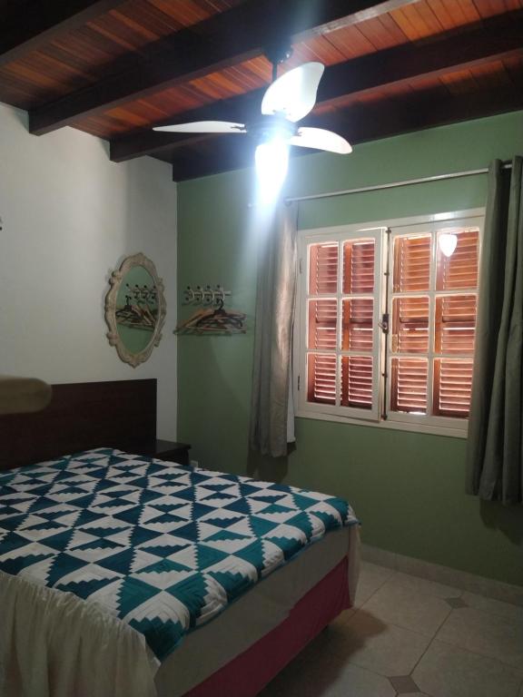 Schlafzimmer mit einem Bett und einem Deckenventilator in der Unterkunft Casa temporada Peró Cabo Frio in Cabo Frio