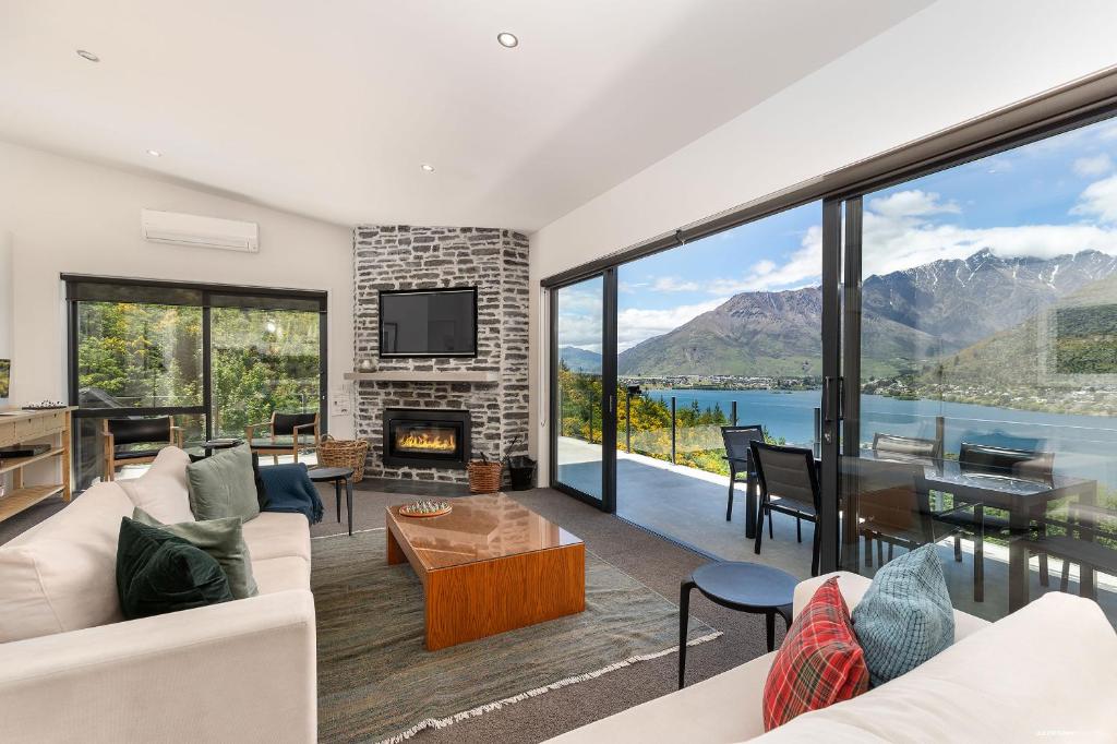 a living room with a view of a lake and mountains at Okataina - Means Place of Laughter, Luxury Retreat in Queenstown