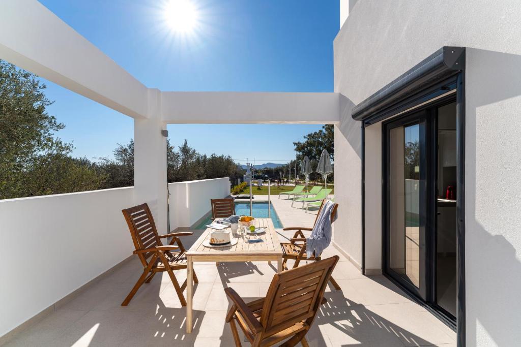 a patio with a table and chairs on a balcony at Domus Oliva Villas in Haraki