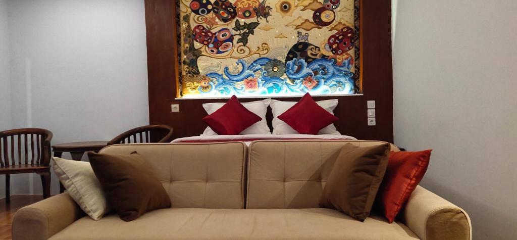 a couch in front of a bed with a painting at Belvilla 93822 Serenity Villa in Pemuteran