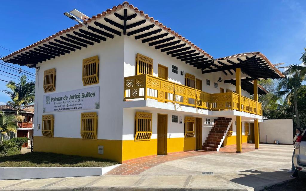 - un bâtiment jaune et blanc avec balcon dans l'établissement Palmar de Jericó Suites, à Jericó