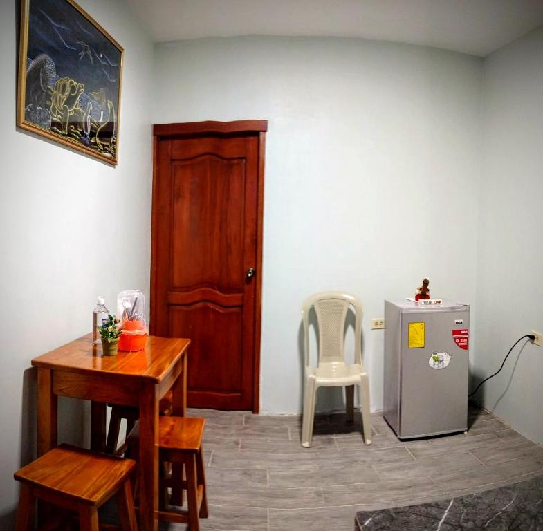 een kamer met een tafel, een koelkast en een stoel bij Casa Scalesia in Puerto Baquerizo Moreno